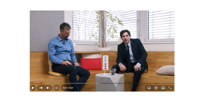 Posnetek zaslona videa na katerem je Tilen Artač (voditelj) z gostom.