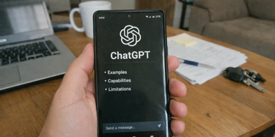 Oseba v roki drži mobilni telefon in uporablja ChatGPT.